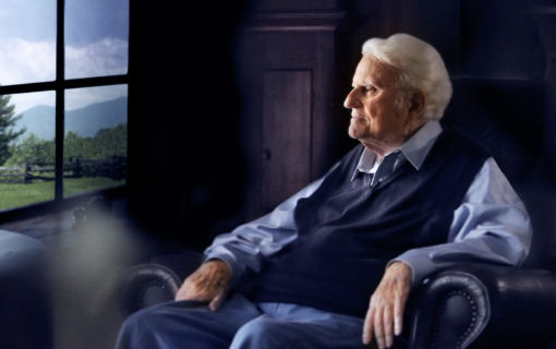 Thumbnail image of Billy Graham, sitting in a chair and looking out a window