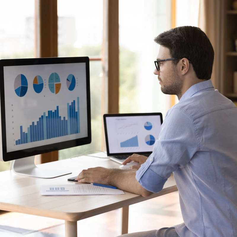 A man looks at charts on a computer screen