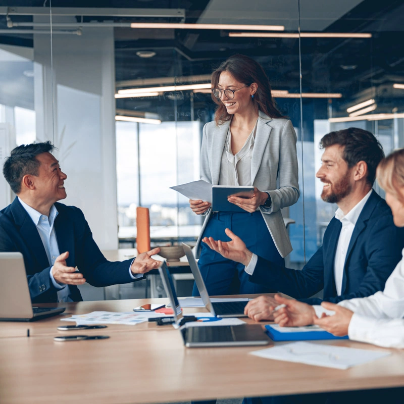 A woman stands and smiles at a man sitting at a table