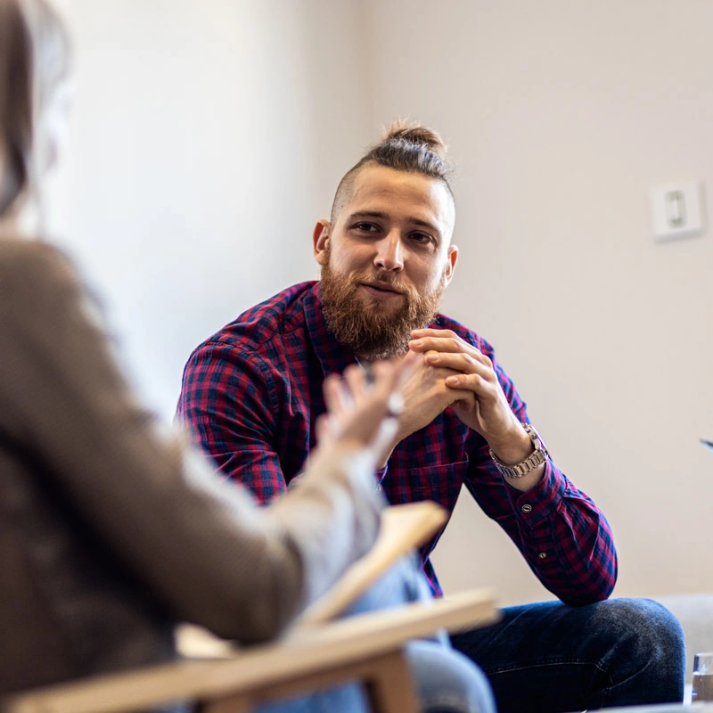A man with a mohawk looks at a woman who is in the foreground and out of focus
