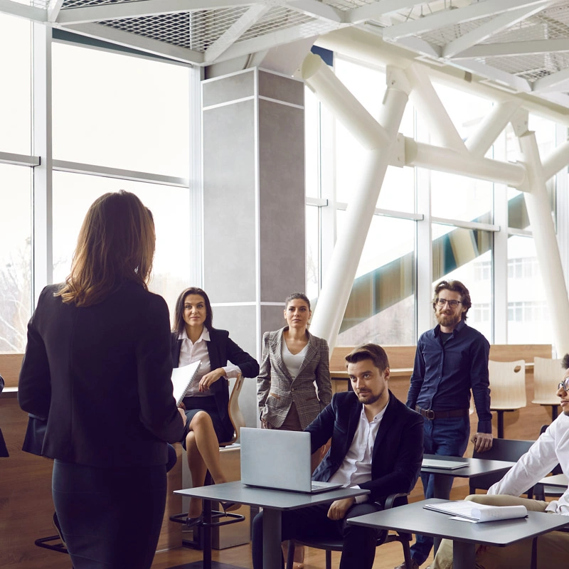 A woman speaks to a group of four other people