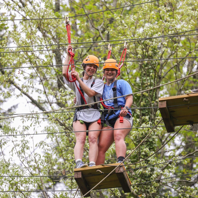 Two young women on a high ropes course