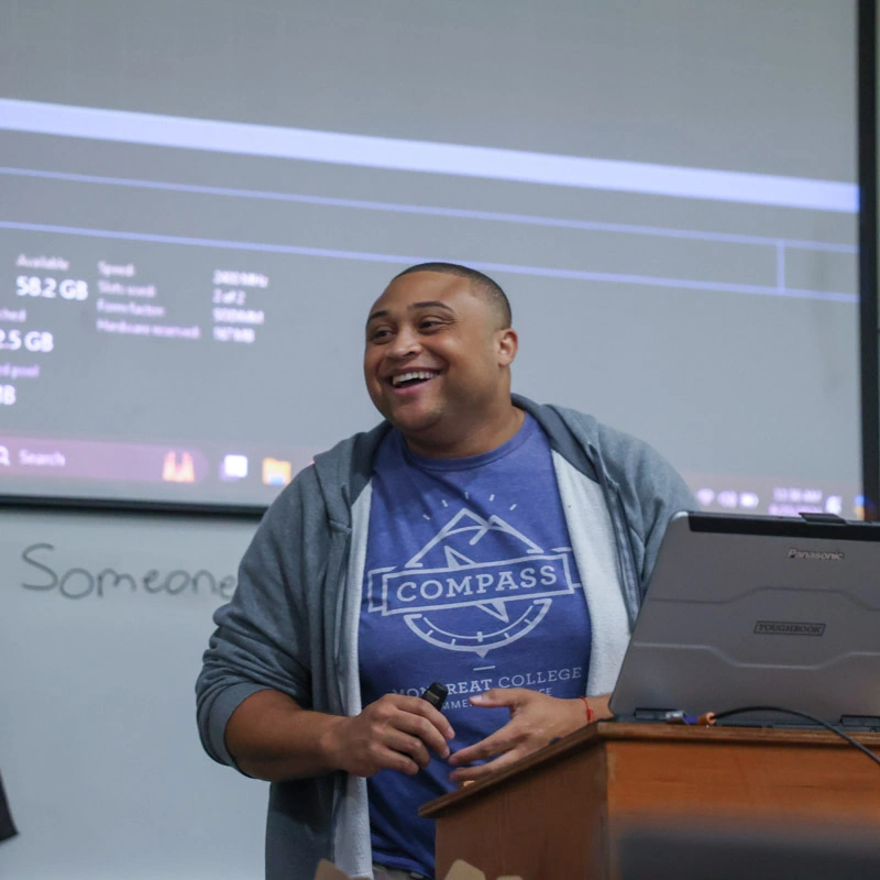 A young man smiles broadly while standing at a podium