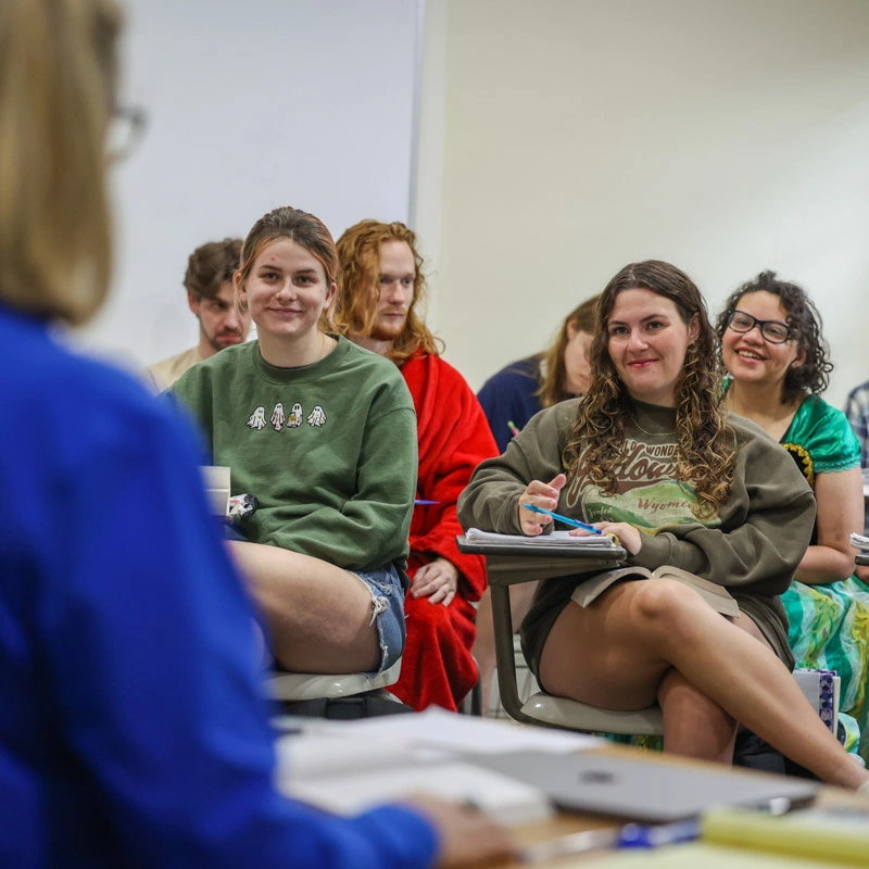 A classroom full of college students smiles