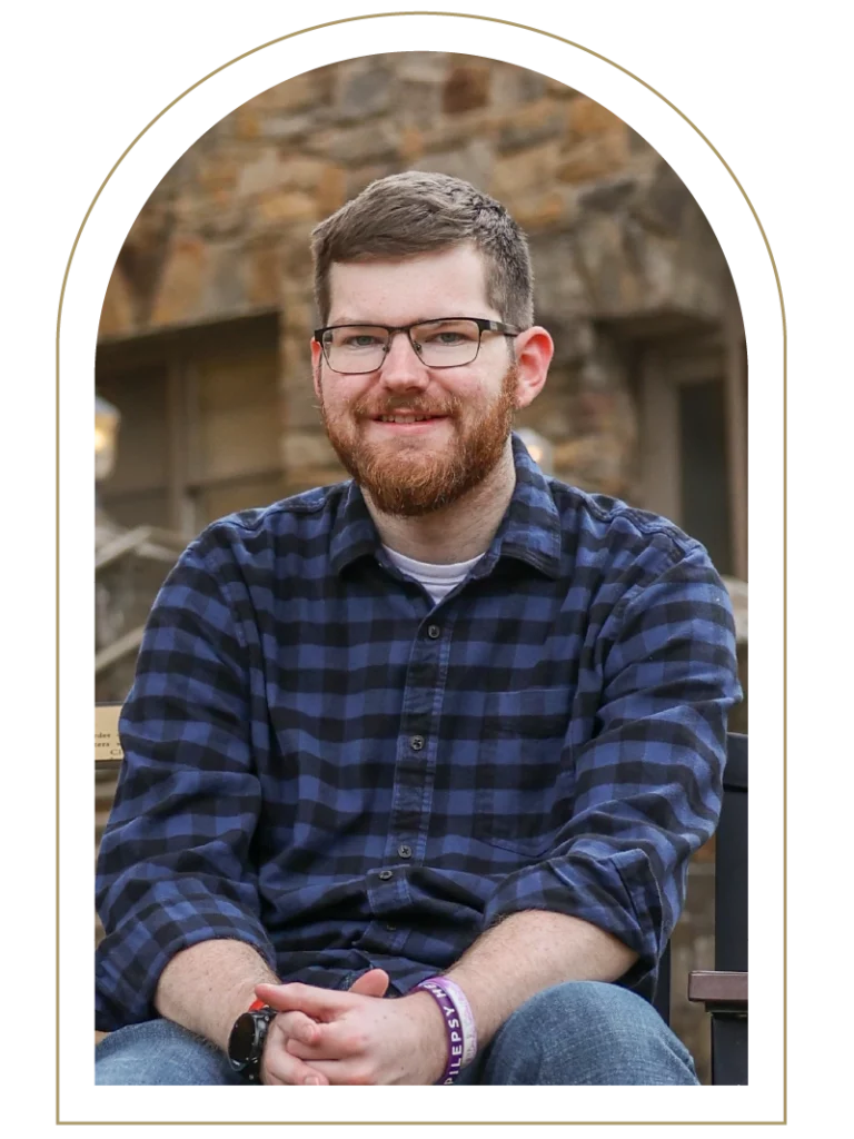 Portrait of a young man wearing a purple and black flannel shirt