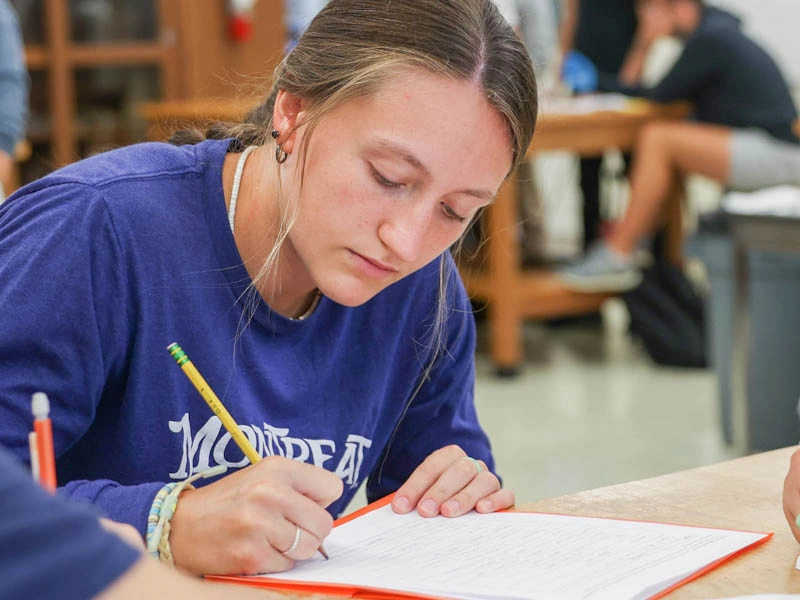 A young woman writes in a notebook
