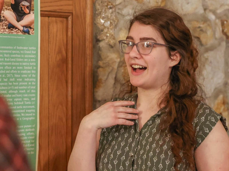 A young woman gestures while speaking