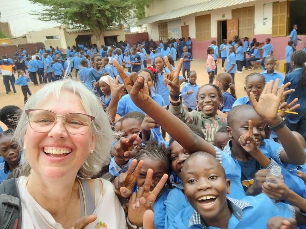 Dorothy Holley with a schoolyard full of enthusiastic children in Senegal