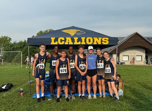 LCA students stand in front of a LCA Lions tent