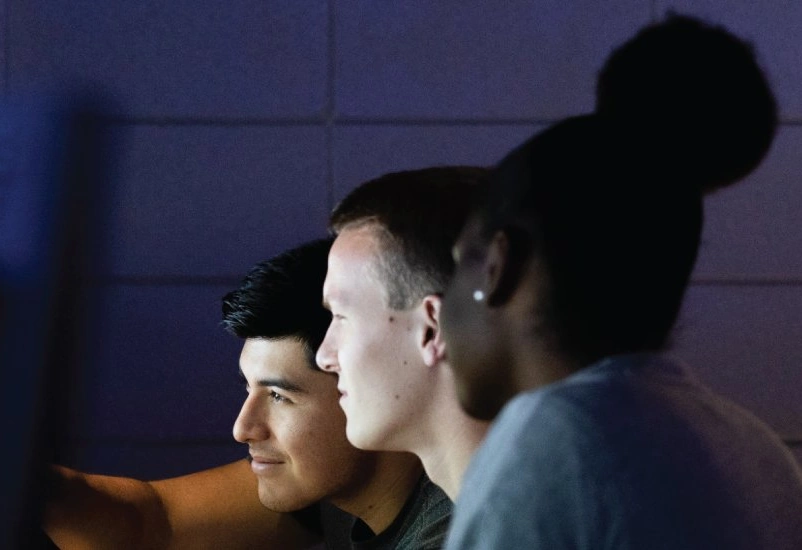 Three people looking at a computer screen