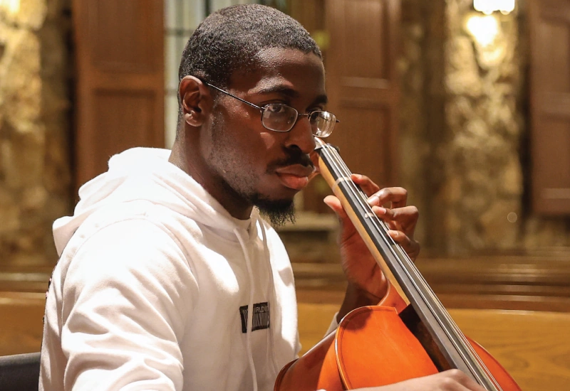 A young man playing a cello in Graham Chapel