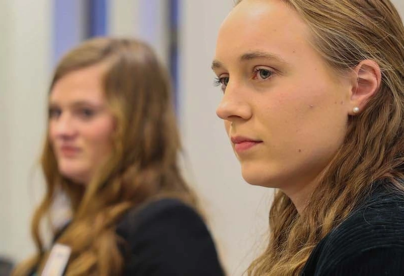 Two young women look to the left