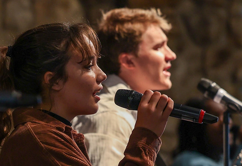 A young man and woman singing on the worship team in Graham Chapel