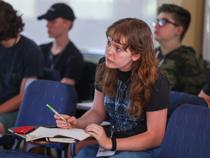 A young woman writes in a notebook