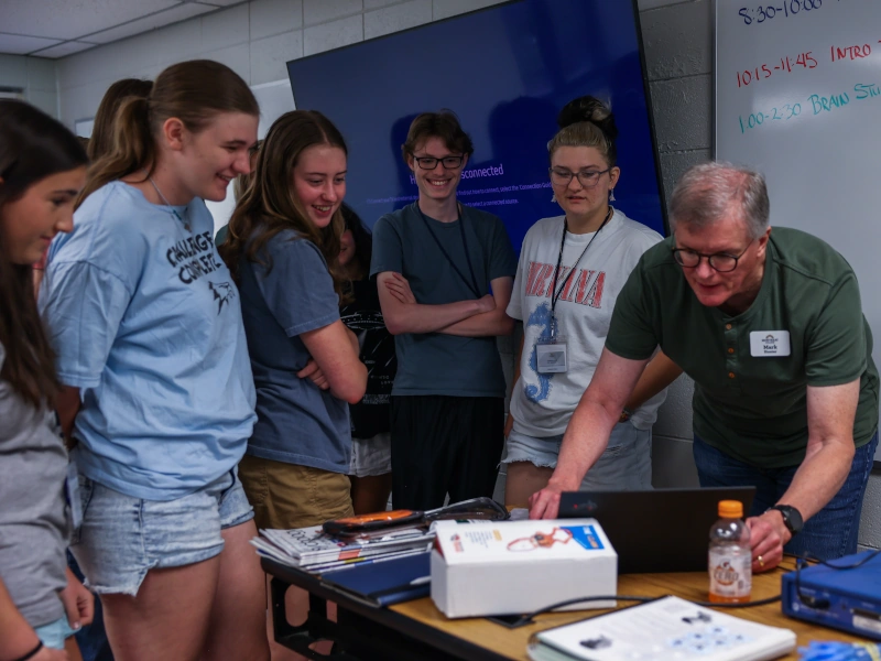 Mark Hunter shows four high school students something on his laptop
