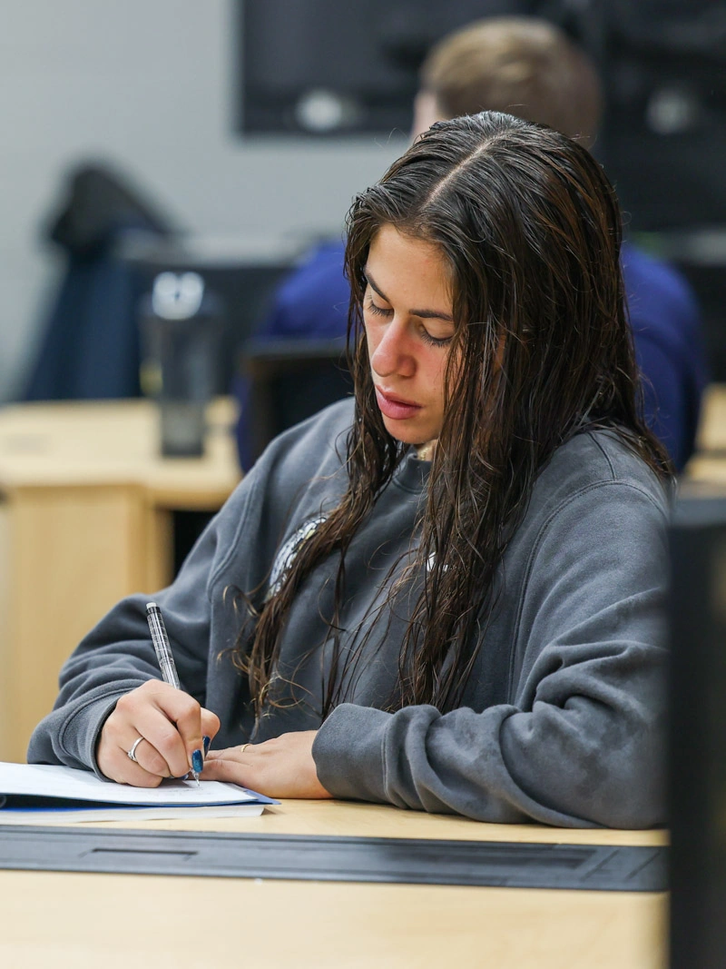 A young woman writes in a notebook