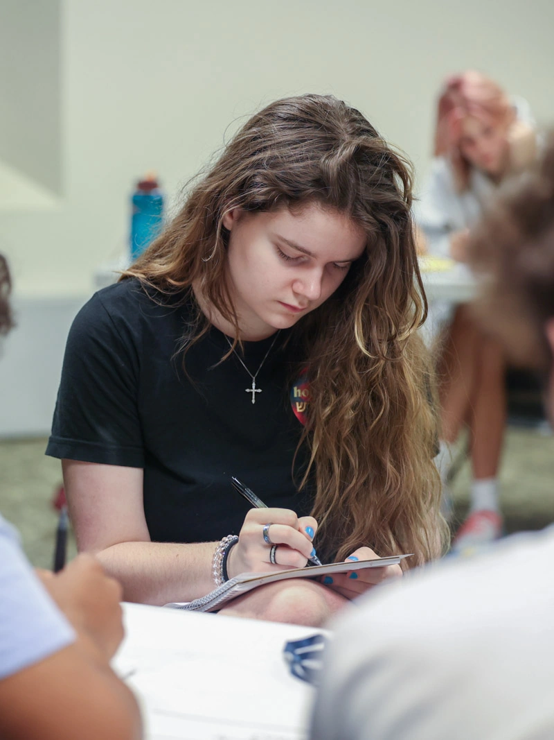 A young woman writes in a notebook