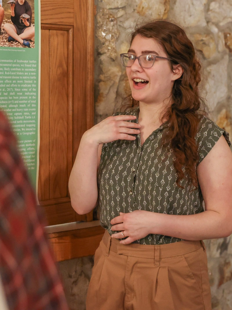 A young woman gestures while making a presentation