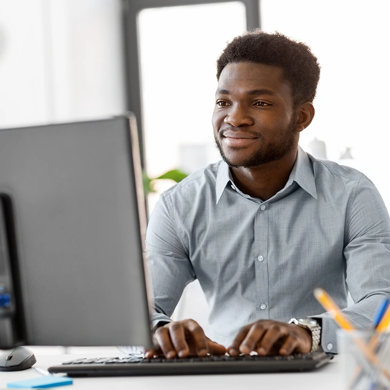 A young man sits at a computer