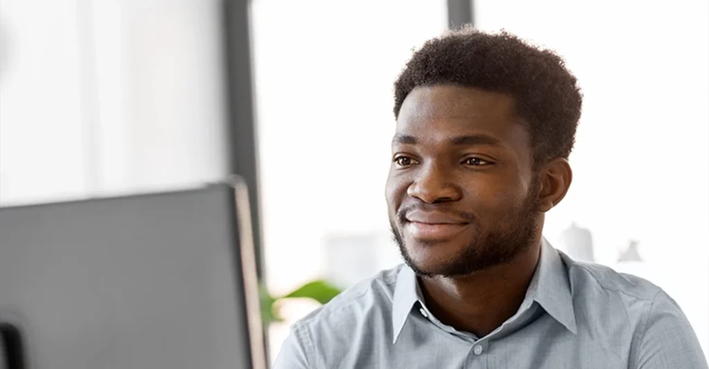 A young man looks at a computer screen