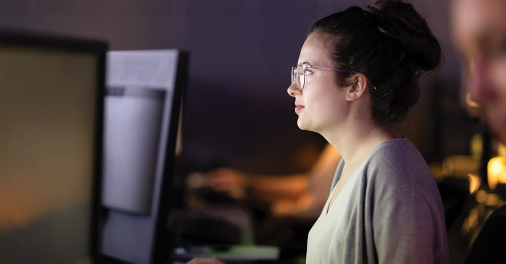 A young woman looks at a computer screen